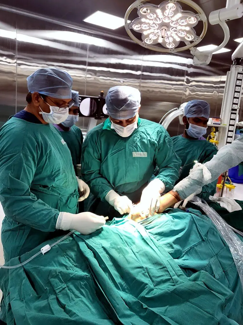 An orthopaedic surgeon in surgical attire during an arthroscopic procedure in theatre